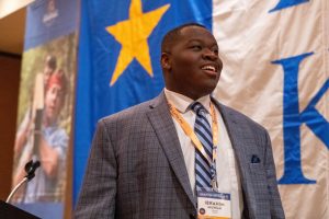 Pi Kappa Phi brother wearing a suit smiling.